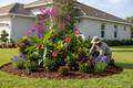Landscaper planting tropical plants in freshly mulched bed